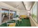 Relaxing sun room featuring green carpet, a fan, and sliding glass doors that open up to the backyard at 10801 W Mountain View Rd, Sun City, AZ 85351