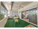 Enclosed sun room with green carpet, white furniture and lots of natural light, perfect for relaxing and entertaining guests at 10801 W Mountain View Rd, Sun City, AZ 85351