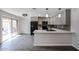 Updated kitchen featuring gray cabinets, stainless steel appliances, a breakfast bar, and modern lighting at 1085 N 84Th Pl, Scottsdale, AZ 85257