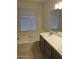 Bright bathroom with a built-in tub and a double sink vanity at 11207 N 59Th Dr, Glendale, AZ 85304