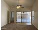 Bright bedroom with neutral carpet, ceiling fan, and a sliding door leading to the patio at 11207 N 59Th Dr, Glendale, AZ 85304