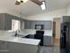 Bright kitchen featuring gray cabinets, white countertops, and modern black appliances at 11207 N 59Th Dr, Glendale, AZ 85304