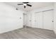 Bright bedroom featuring a ceiling fan, sliding door closet, and gray wood-look floors at 12235 N 36Th Dr, Phoenix, AZ 85029