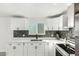 Updated kitchen features white cabinets, stainless steel appliances, mosaic backsplash and light countertops at 12235 N 36Th Dr, Phoenix, AZ 85029