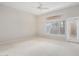 Neutral bedroom with carpet, a large window, and a patio door at 14621 W Black Gold Ln, Sun City West, AZ 85375