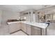 Bright kitchen with tile floor, stainless steel dishwasher, white countertops and view into breakfast nook at 14621 W Black Gold Ln, Sun City West, AZ 85375