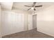 Neutral bedroom features carpet, ceiling fan, and a closet with shutter doors at 1575 W Hazelwood St, Phoenix, AZ 85015