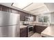 Traditional-style kitchen with stainless steel appliances, tile countertops, and dark cabinets at 1575 W Hazelwood St, Phoenix, AZ 85015