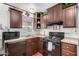 Well-maintained kitchen with dark wood cabinets, modern appliances, and a window at 201 S Greenfield Rd # 254, Mesa, AZ 85206