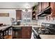 Well-appointed kitchen with dark wood cabinets and sleek black appliances at 201 S Greenfield Rd # 254, Mesa, AZ 85206