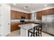 Kitchen featuring wood cabinets, granite counters, stainless steel appliances, and an island with bar stools at 2090 S Dorsey Ln # 1020, Tempe, AZ 85282