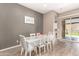 Dining area featuring wood-look floors, a modern table setting, and seamless access to the outdoor patio for al fresco dining at 21258 W Wilshire Dr, Buckeye, AZ 85396