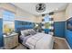 Charming bedroom with blue accent wall, stylish furnishings, and modern decor at 26217 N 19Th Ln, Phoenix, AZ 85085