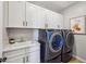 Well-lit laundry room with new washer and dryer, white cabinets, sink, and light countertop at 26217 N 19Th Ln, Phoenix, AZ 85085