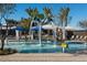 Community splash pool with water features, lounge chairs and umbrellas on a sunny day at 26217 N 19Th Ln, Phoenix, AZ 85085