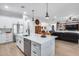 Open kitchen with white cabinets, a central island, stainless steel appliances, and seamless flow to the living area at 28211 N Quintana Pl, Queen Creek, AZ 85144