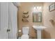 Cozy bathroom featuring a pedestal sink, framed mirror, floating shelves with decor, and a shower with a curtain at 2966 S Country Club Way, Tempe, AZ 85282