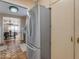 Modern stainless steel refrigerator in a kitchen area with terracotta floors and adjoining rooms at 2966 S Country Club Way, Tempe, AZ 85282