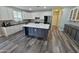 Spacious kitchen showcases white cabinetry, stainless steel appliances, large island, and stylish wood flooring at 3062 E Cullumber St, Gilbert, AZ 85234