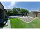 Backyard with refreshing pool, patio area, green grass, and mature trees, perfect for outdoor entertaining at 3062 E Cullumber St, Gilbert, AZ 85234