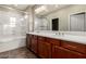 Bathroom boasts double vanity, cabinet storage, a full-sized mirror, and a glass-enclosed shower and tub at 3935 E Rough Rider Rd # 1076, Phoenix, AZ 85050