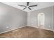 Carpeted bedroom features a ceiling fan and an arched doorway leading to the bathroom at 3935 E Rough Rider Rd # 1076, Phoenix, AZ 85050