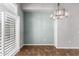 A dining room has a modern chandelier and plantation shutters for natural light at 3935 E Rough Rider Rd # 1076, Phoenix, AZ 85050