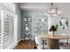 A dining room with modern chandelier, plantation shutters, and shelving for decor at 3935 E Rough Rider Rd # 1076, Phoenix, AZ 85050