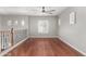 Upstairs loft with hardwood floors, a large window, and a ceiling fan at 3935 E Rough Rider Rd # 1076, Phoenix, AZ 85050