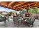 Inviting outdoor living space with fireplace, comfortable seating and overhead wood beamed structure at 3935 E Rough Rider Rd # 1076, Phoenix, AZ 85050