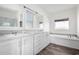 Bathroom featuring double sinks, separate tub and shower, and natural light at 4111 N 313Th Ave, Buckeye, AZ 85396