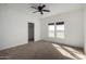 Bright bedroom with carpet, two windows, and a ceiling fan at 4111 N 313Th Ave, Buckeye, AZ 85396