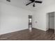 This bedroom has wood-look laminate floors, a ceiling fan, and a doorway to a large closet at 4111 N 313Th Ave, Buckeye, AZ 85396