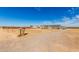 Expansive lot with a manufactured home in the distance, offering ample space for outdoor activities at 4111 N 313Th Ave, Buckeye, AZ 85396