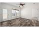 Bright living room features modern ceiling fan, wood-look flooring, and ample natural light at 4111 N 313Th Ave, Buckeye, AZ 85396