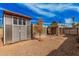 Exterior shot showing backyard shed and covered patio with a desert landscape at 4116 N 105Th Ln, Phoenix, AZ 85037
