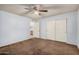 Carpeted bedroom with ceiling fan and closet at 4116 N 105Th Ln, Phoenix, AZ 85037