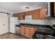 Galley kitchen featuring stainless steel appliances, marble backsplash, and wooden cabinets at 4116 N 105Th Ln, Phoenix, AZ 85037