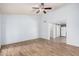 A brightly illuminated living room featuring tile flooring, a ceiling fan, and an open layout into the kitchen at 4116 N 105Th Ln, Phoenix, AZ 85037