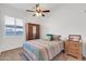The bedroom features a ceiling fan, a window letting in natural light, and a wardrobe with a mirror at 4365 S Columbine Way, Gold Canyon, AZ 85118