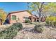 Back of home showcasing lush desert landscaping, covered patio and mature trees at 4365 S Columbine Way, Gold Canyon, AZ 85118