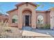 Charming home featuring a covered entrance, arched windows, and desert landscaping at 4365 S Columbine Way, Gold Canyon, AZ 85118