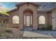 Charming home featuring a covered entrance, arched windows, and desert landscaping at 4365 S Columbine Way, Gold Canyon, AZ 85118