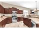 Modern kitchen with dark wood cabinets, granite countertops, stainless steel appliances and travertine flooring at 4365 S Columbine Way, Gold Canyon, AZ 85118