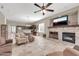 Open-concept living room with stone fireplace, tile floors, and seamless flow into the kitchen and dining areas at 4365 S Columbine Way, Gold Canyon, AZ 85118
