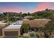 Expansive aerial view of a well-maintained home with a lush landscape, a tennis court, and mountain views at 4448 E Camelback Rd # 16, Phoenix, AZ 85018