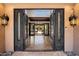 Elegant foyer with decorative iron doors opening to a view of the beautiful, landscaped outdoor living space beyond at 4448 E Camelback Rd # 16, Phoenix, AZ 85018
