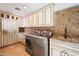 Well-organized laundry room with custom cabinets, granite countertops, and modern appliances at 4448 E Camelback Rd # 16, Phoenix, AZ 85018