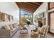 Bright living room with wood beamed ceilings, expansive windows offering picturesque views, and grand piano at 4448 E Camelback Rd # 16, Phoenix, AZ 85018