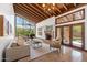 Bright living room boasts vaulted wood ceilings, large windows, a stone fireplace, and seamless access to outdoor spaces at 4448 E Camelback Rd # 16, Phoenix, AZ 85018